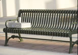 Bench with sculptures of brief case and cup on one end of bench